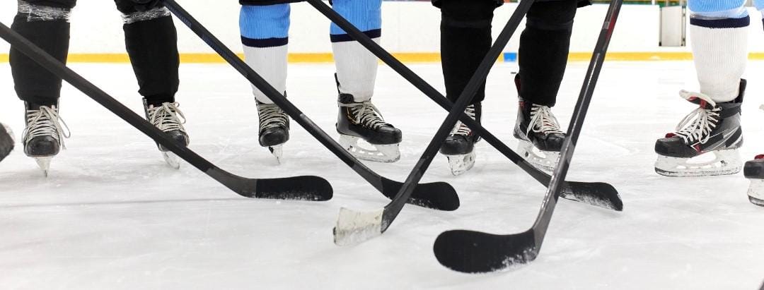close up image of hockey skates and sticks