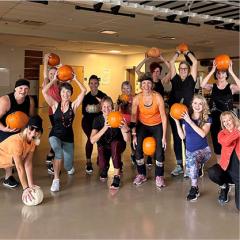 Group photo of fitness class holding pumpkins
